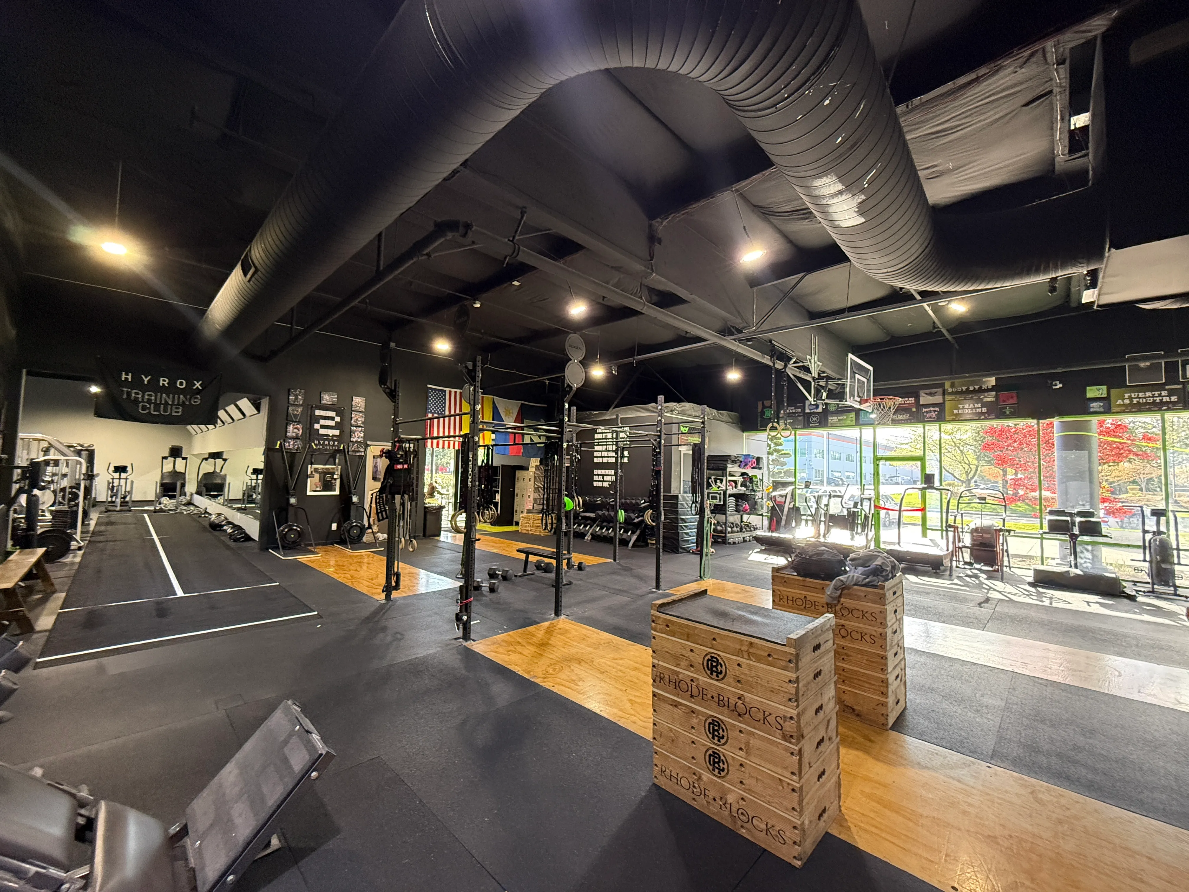 Functional training floor with a large green Get RX'd rig, rings, ropes, and organized strength equipment.