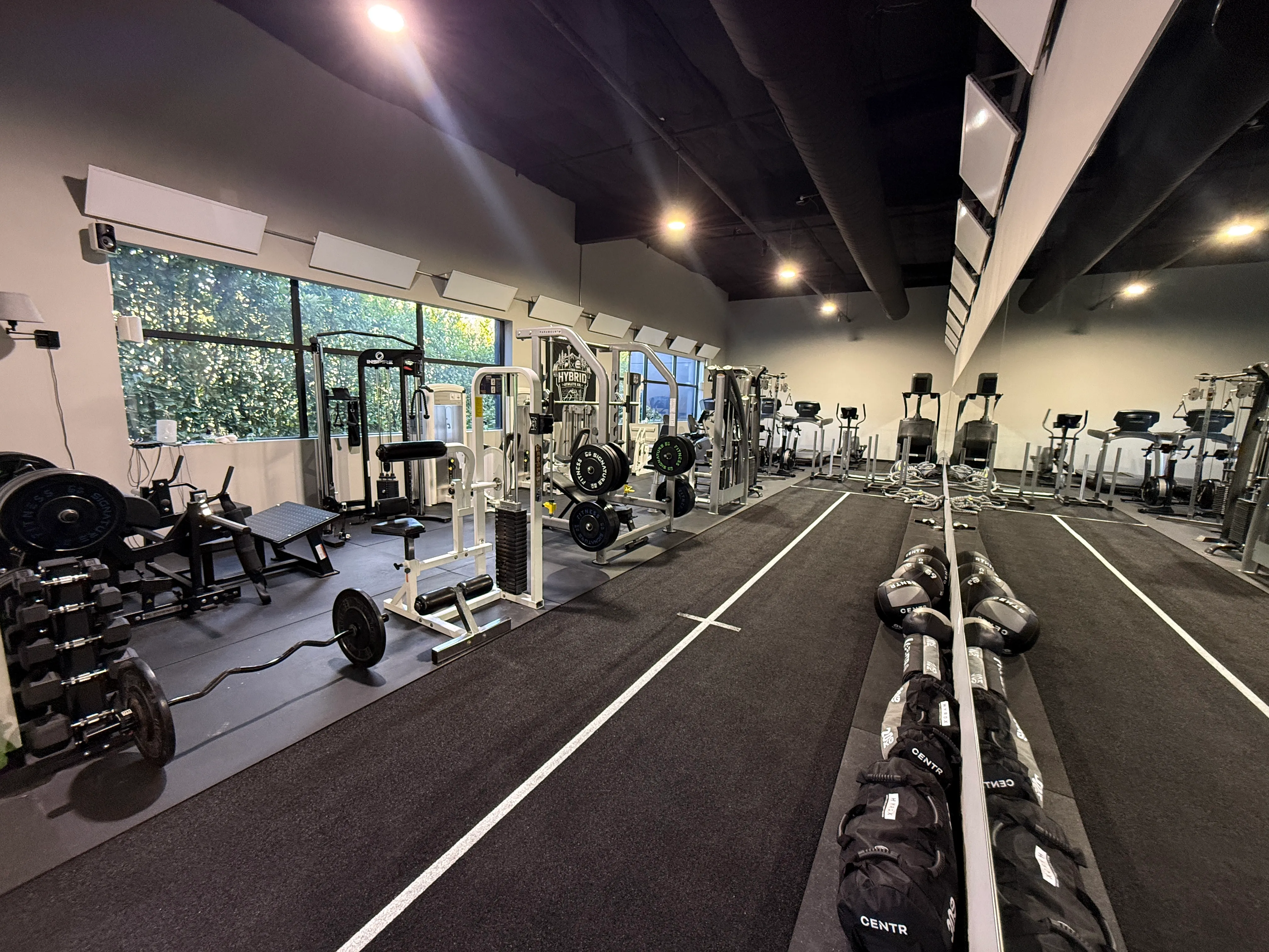 Dedicated turf track with HYROX Training Club banner and mirrored training space.